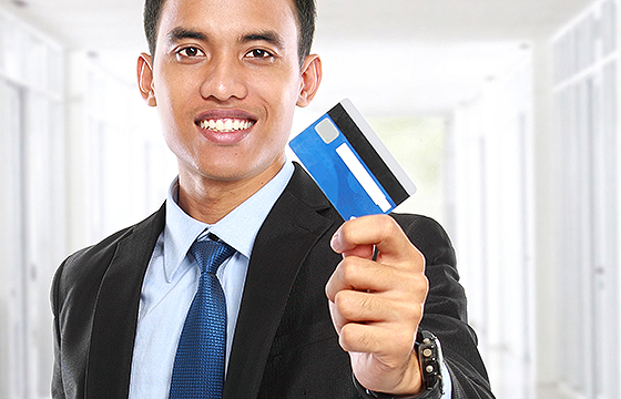 asian businessman holding credit or debit card
