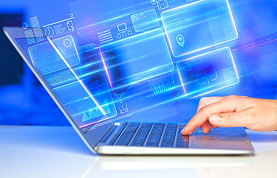 hand using laptop with graphics flying out of the screen