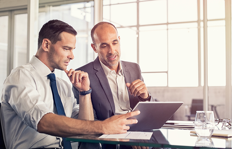 Businessman,Using,A,Digital,Tablet,To,Discuss,Information,With,Senior