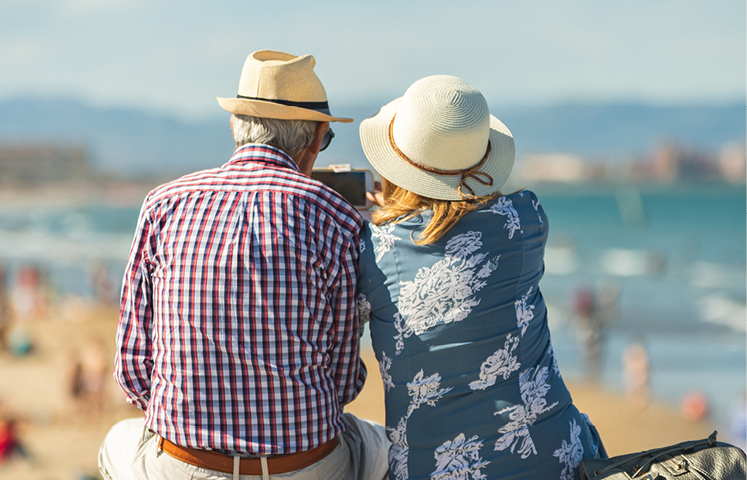 retired couple sitting on beach