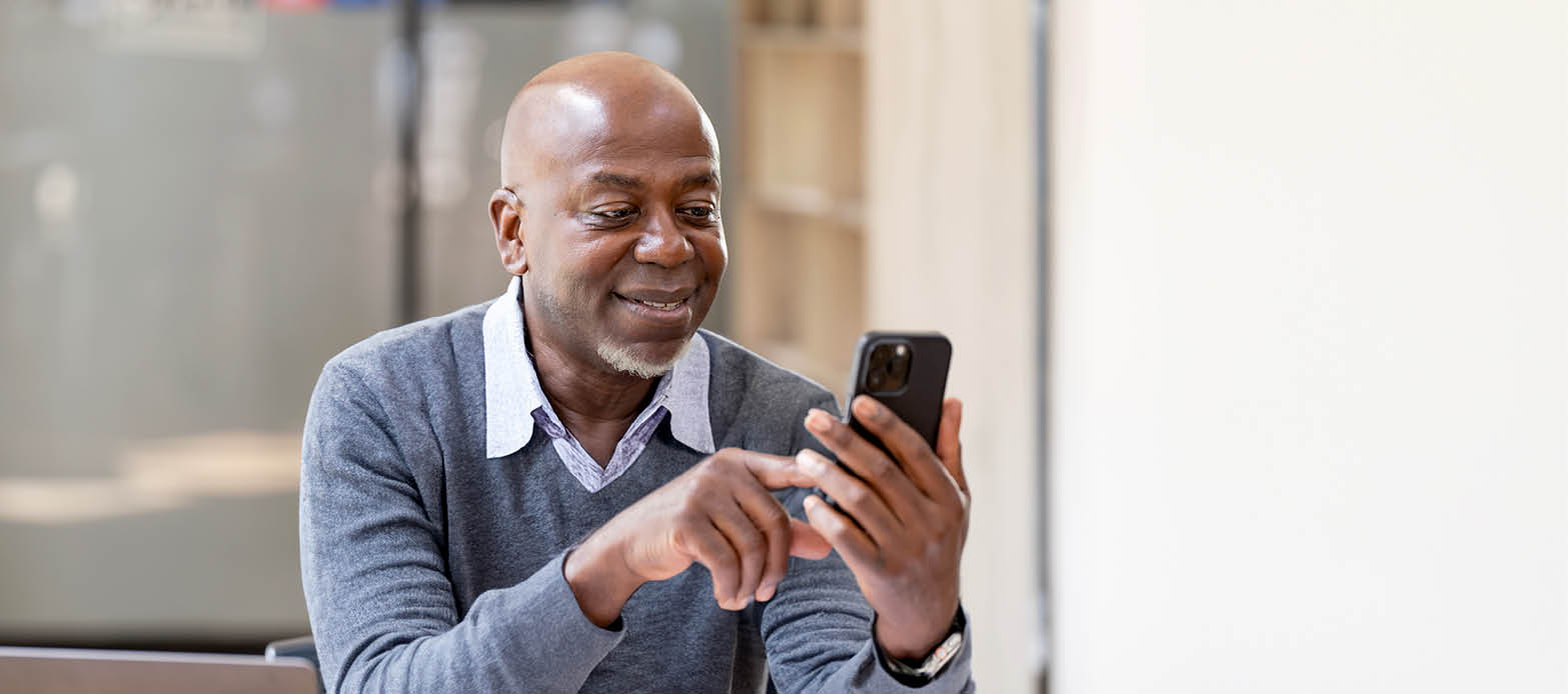 Man sitting down looking at cell phone.