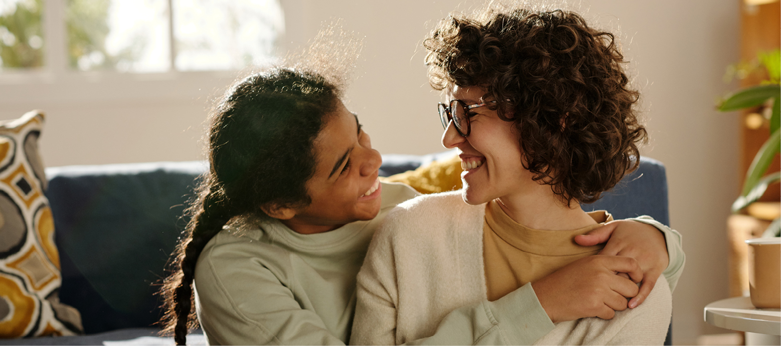 Mother and daughter hugging and smiling