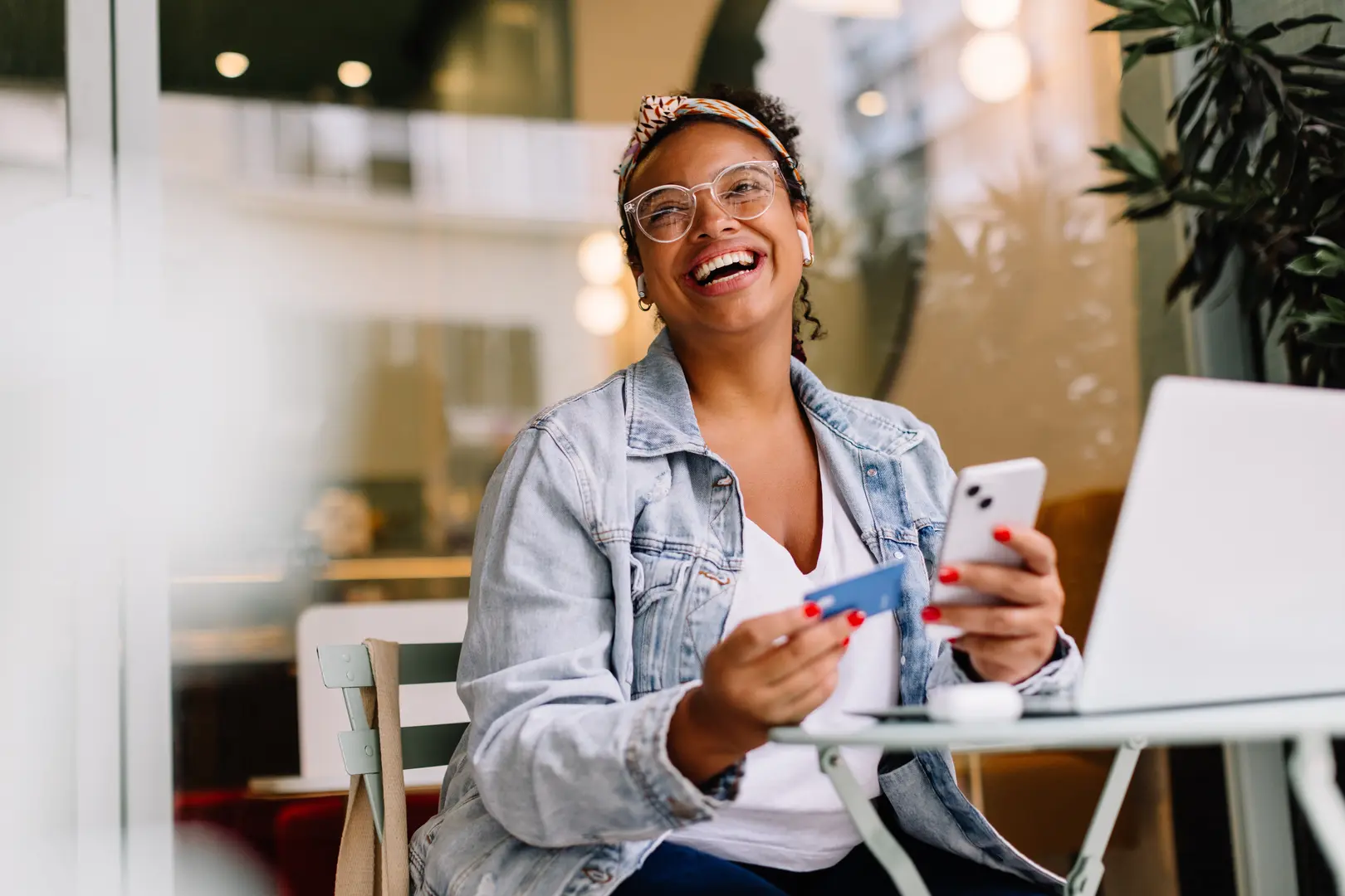 African American woman smiles while mobile banking while on a patio