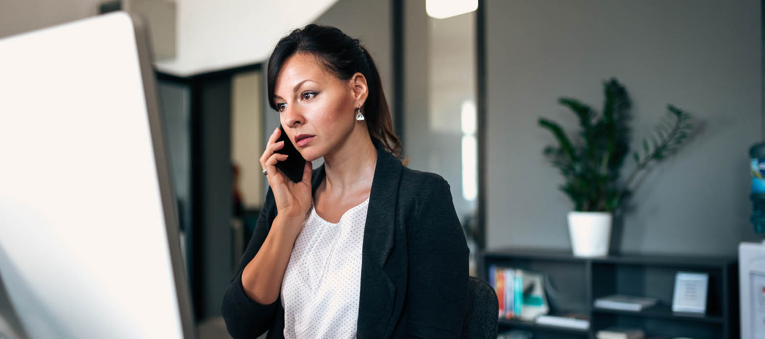 Woman on the phone looks at computer screen
