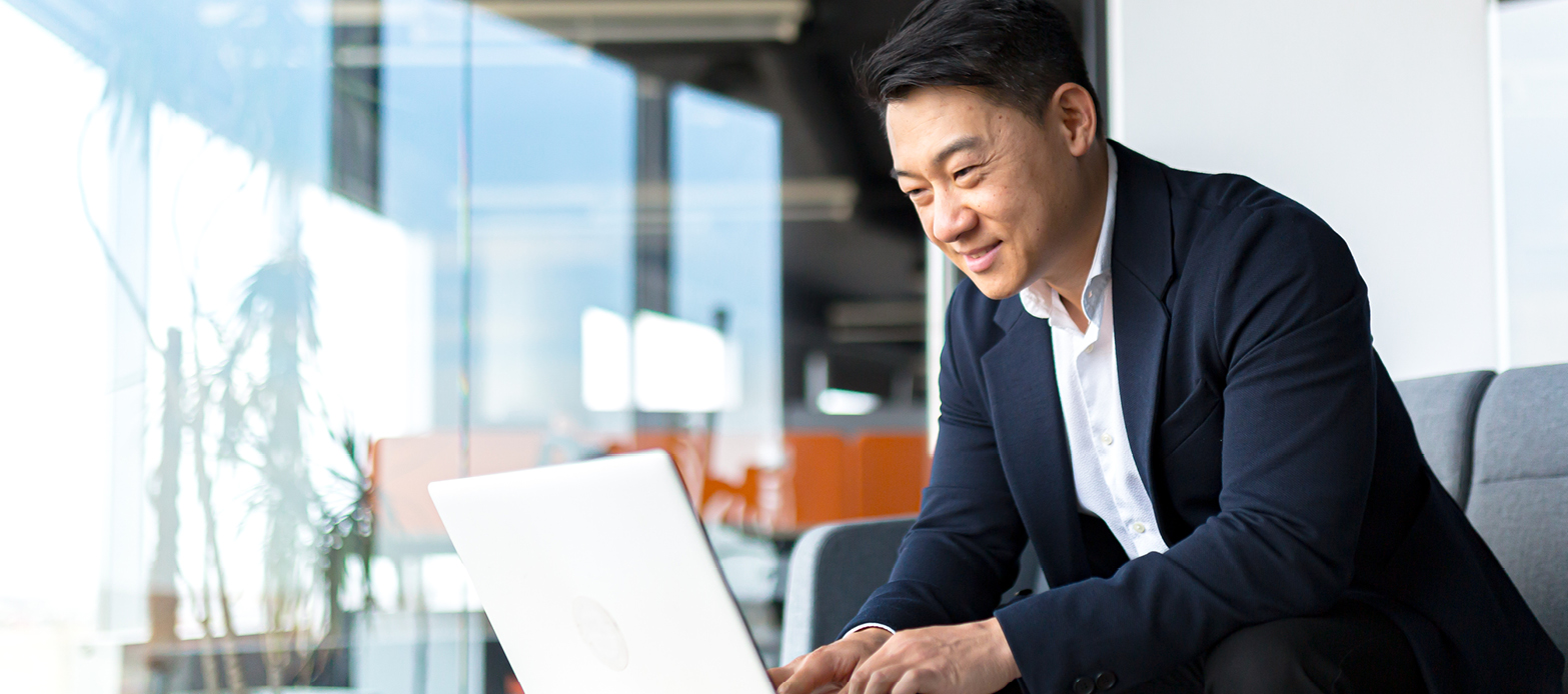Asian man works on laptop