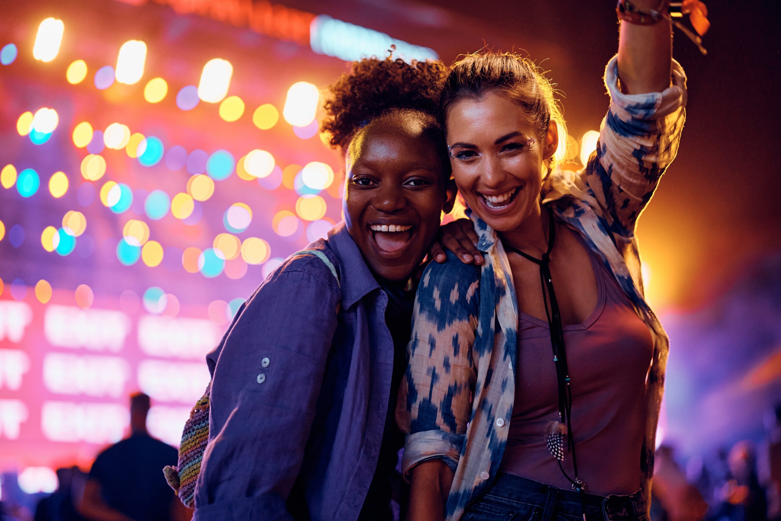 Two friends pose at a concert