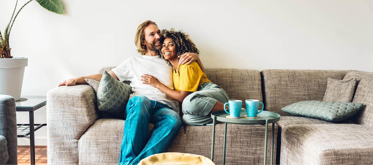 Couple cuddles on a sectional in their home
