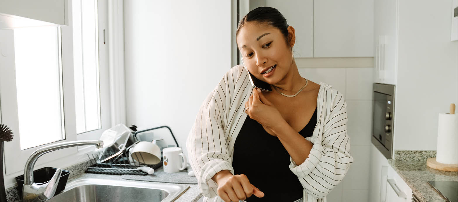 Woman on her phone in her kitchen