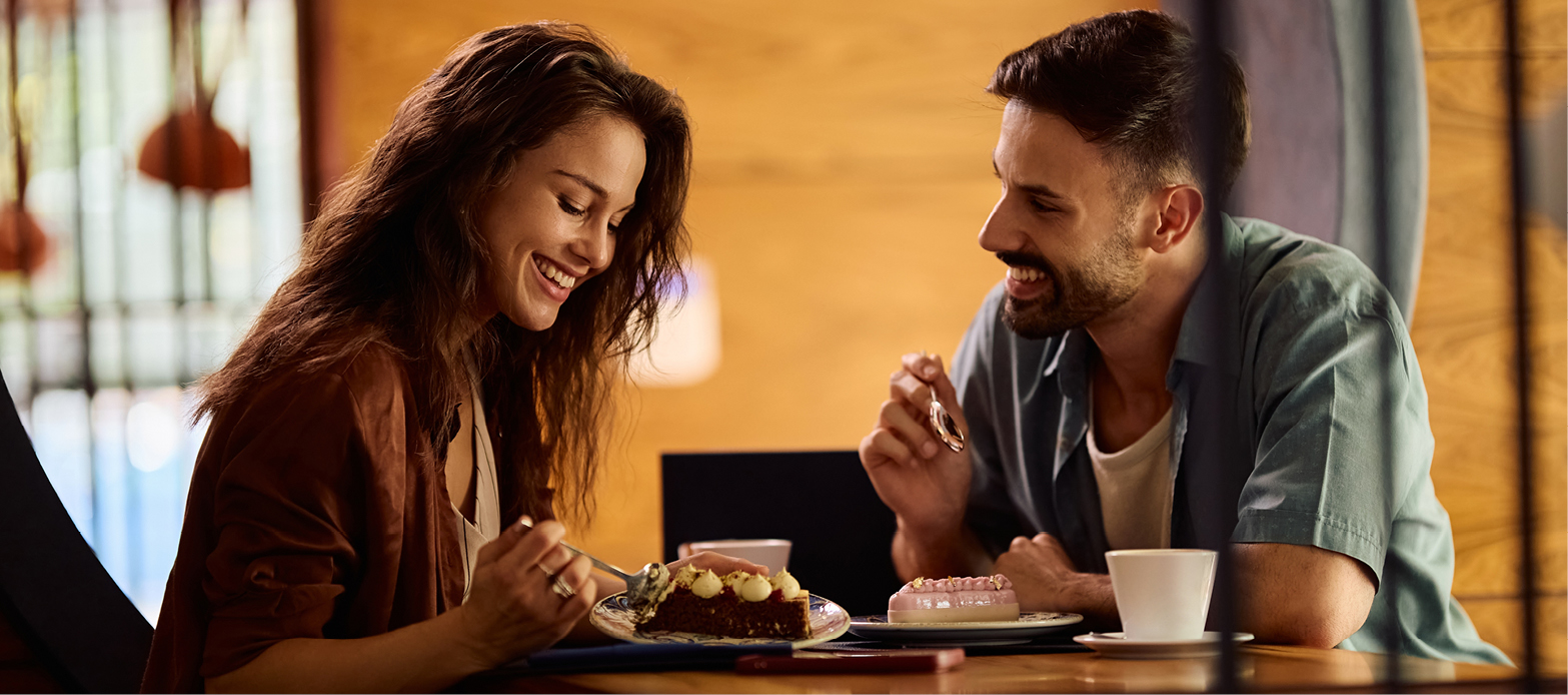 Two people sitting and talking while eating food