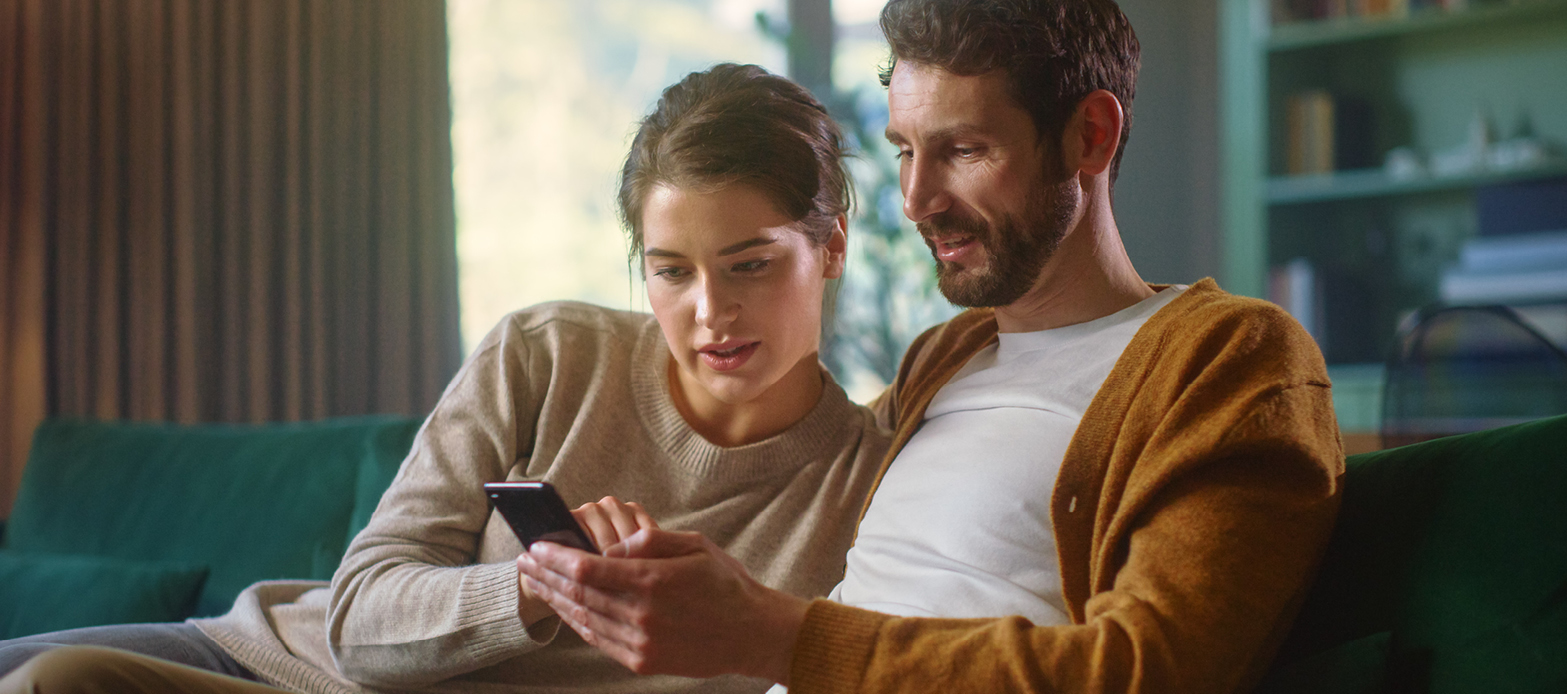 A man and a woman looking at a phone screen
